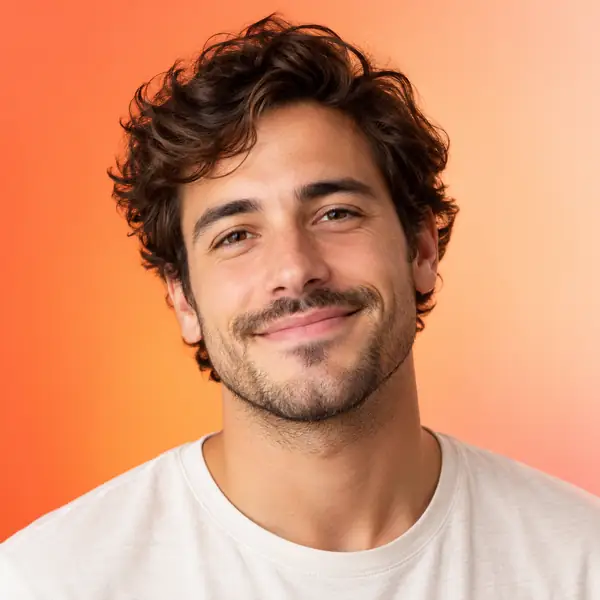 Retrato de un hombre de aspecto amable frente a un fondo con un suave degradado de naranja a melocotón